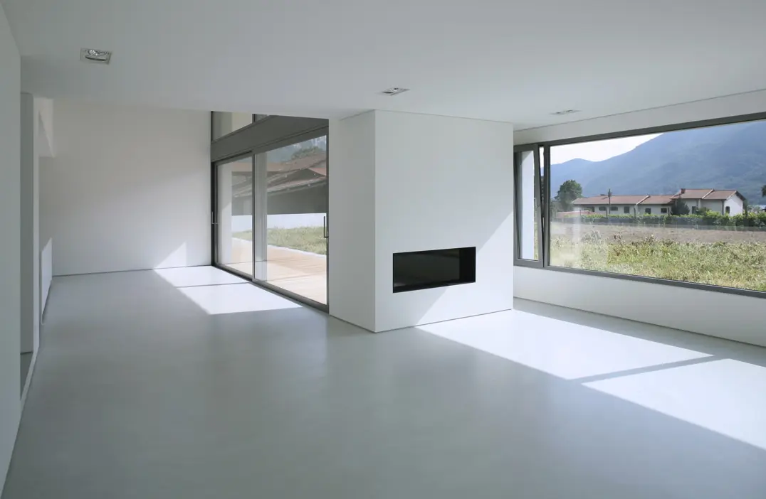 Microcement floor in an empty living room with views to the countryside