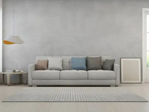 Sala de estar en tonalidades grises con pared de microcemento en Castellón