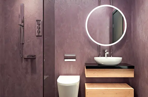 Baño de microcemento que se combina con muebles de madera y un espacio abierto que conecta el lavabo con la ducha