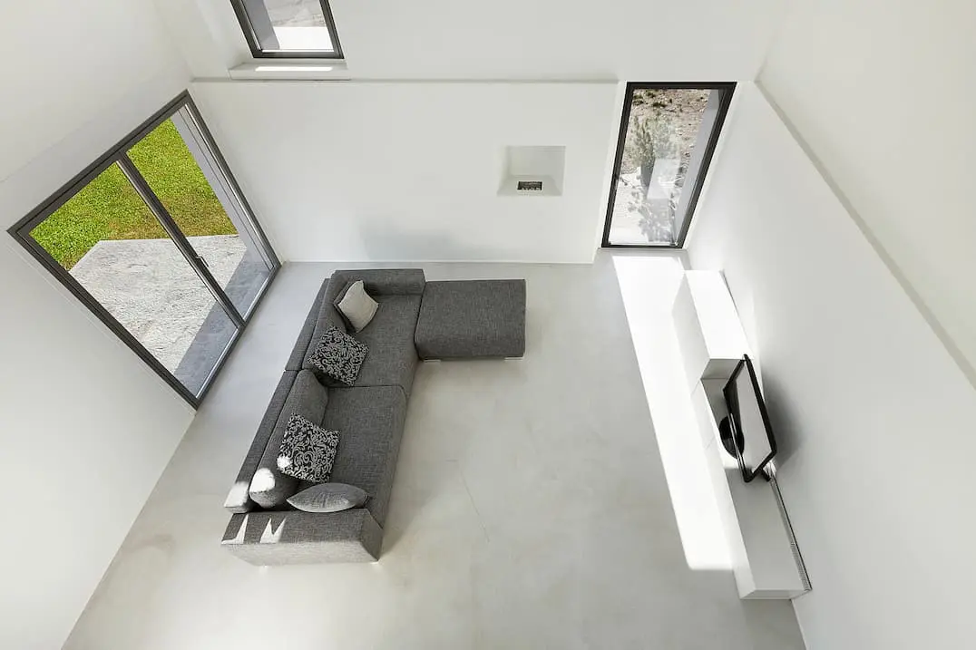 Mikrocement i ett minimalistiskt vardagsrum med vita och gråa toner